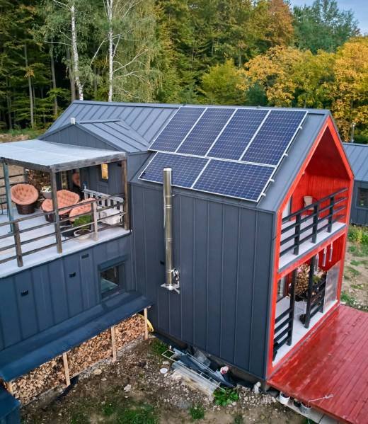 New modern house cottage with solar photovoltaic panel system on roof. Aerial view. New modern house cottage with solar photovoltaic panel system on roof. Aerial view. Concept of alternative, renewable energy and home autonomy.